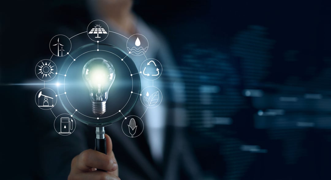 Man holding magnifying glass and light bulb ,search of global show the worlds consumption with icons energy sources for renewable, sustainable development.